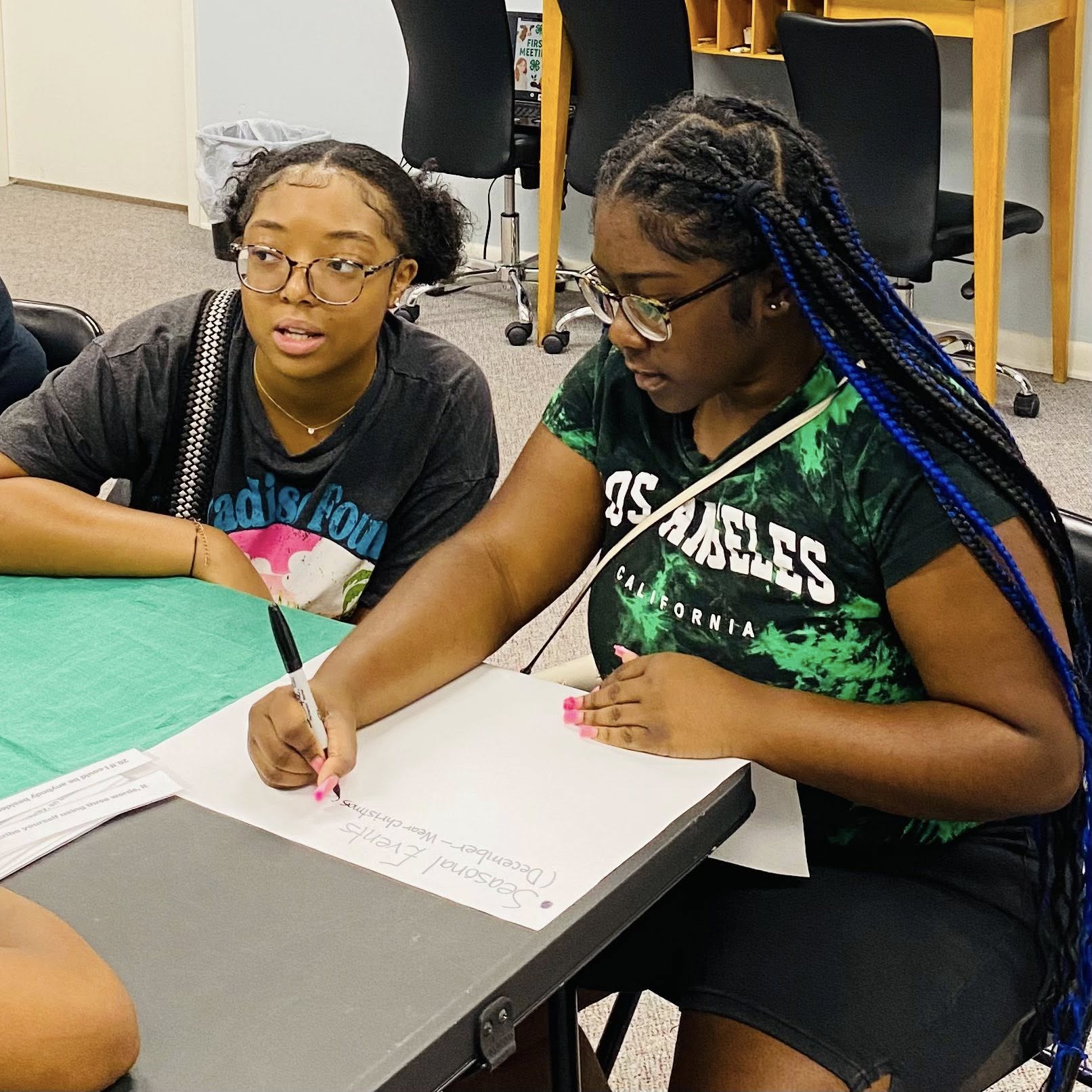 Two teenage girls working on a poster.